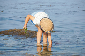 A girl who plays with water at the sea. A girl who grabs something on the beach. 海で水遊びをする女の子　浜辺で何かをつかむ女の子