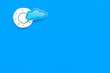 Clear and cloudly weather icons on blue background top view copy space