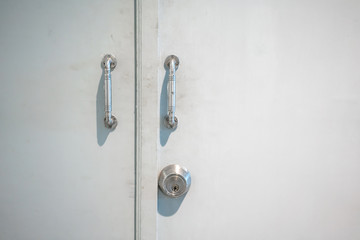 Dirty metal door handle and key on white wooden door