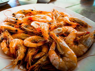 Fresh baked shrimp on a white plate in a restaurant.