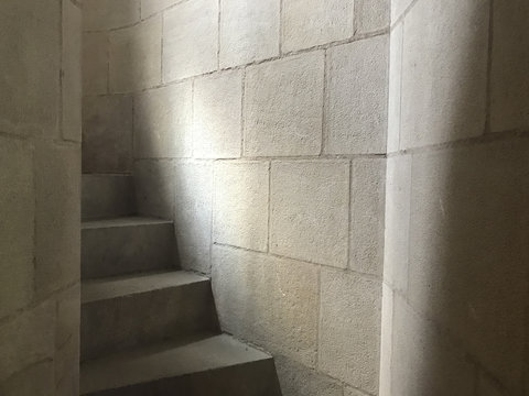 Detail of stairs leading up narrow corridor, sunlight filtering through small window