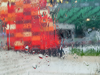 Wet window with drops of water and a blurry background