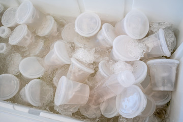 Young coconut water in plastic cups and bottles soaked in ice box