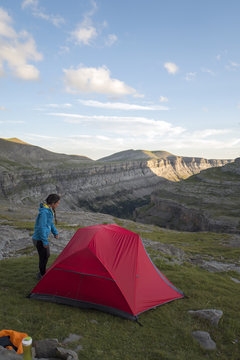 Female hiker entering in a tent