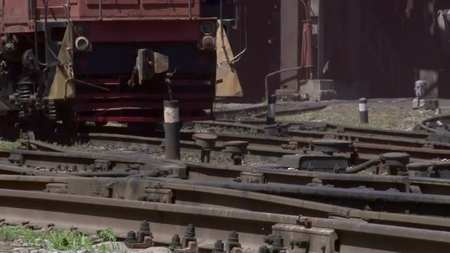 wheels of a freight train traveling slowly on rails
