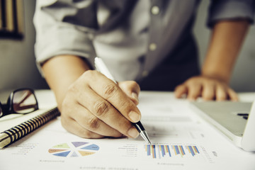 Business people are working on accounts in business analysis with graphs and documentation.