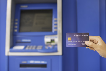 Naklejka premium Hand inserting with a credit card into bank machine . Man using an atm machine with credit card to withdraw money