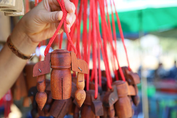 Closeup of wooden cowbells show by woman's hand in the market.