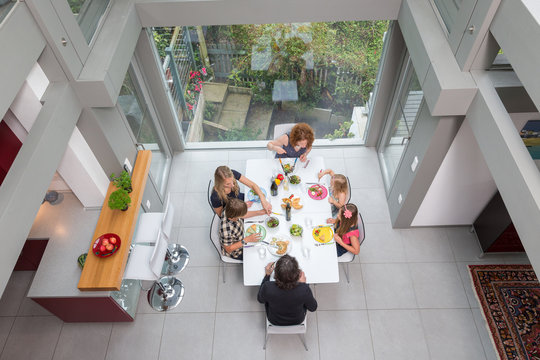 Elevated View Of A Family At Lunch In A Modern Home.