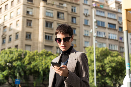 Stylish short haired business woman commuting between meetings on a busy city