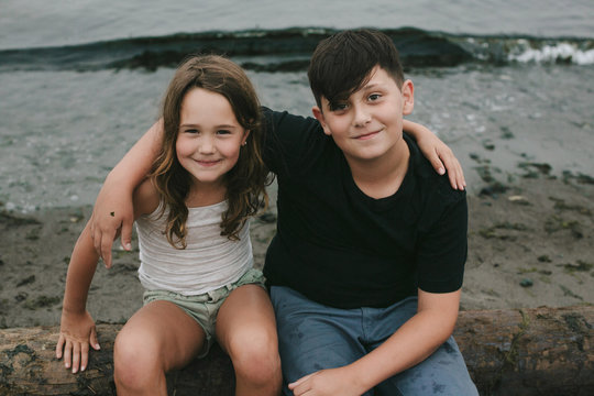 Two kids posing on the beach on cloudy day