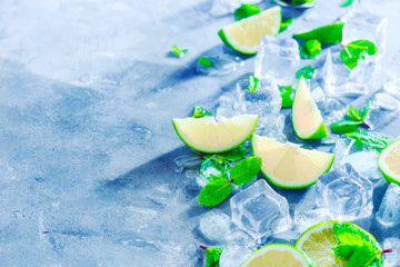 Mint, lime and ice cubes, mojito cocktail ingredients header with copy space. Making summer drinks close-up. Sunlight and refreshment concept.