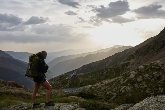 Young woman backpacker enjoying the sunrise in the mountains