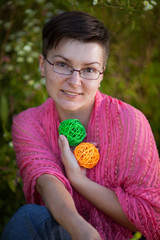 Portrait of attractive woman with short hair and glasses and pink scarf at daytime outdoor