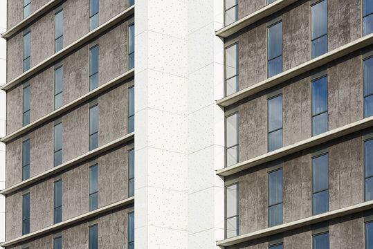 Grey and white building facade with windows.