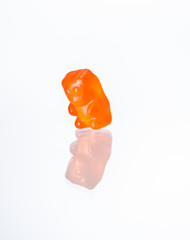 Orange gummy bear close up looking at reflection