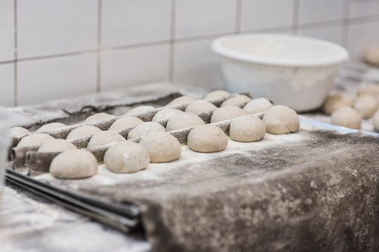 Raw bread rolls proofing on baking tray
