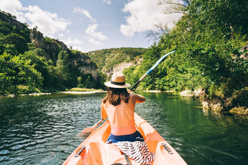 paddler in a canoe on a river in a lush green valley
