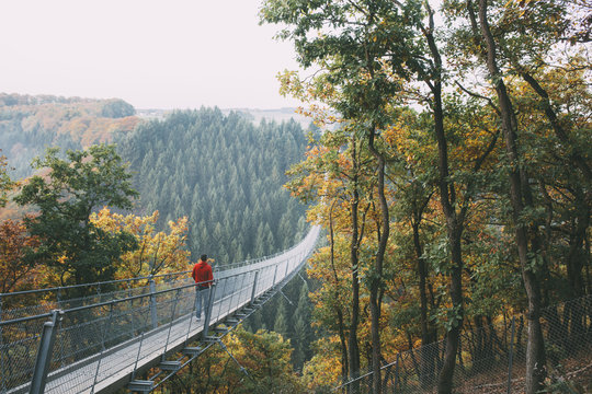 Man walking on a long bridge in nature