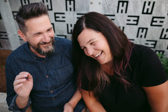 Happy couple enjoying laughing together outside in urban city