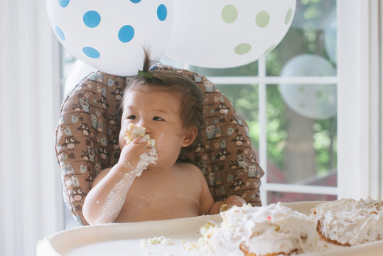 Baby eating first birthday cake