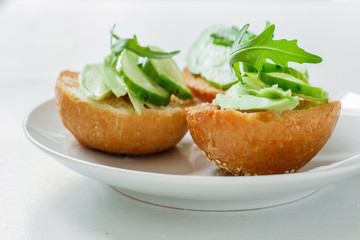Vegetarian appetizer with avocado, cucumber and arugula on a roll