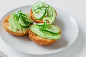 Vegetarian appetizer with avocado, cucumber and arugula on a roll