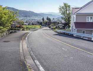 Curved road of Yufuin village surrounded by mountains in Japan