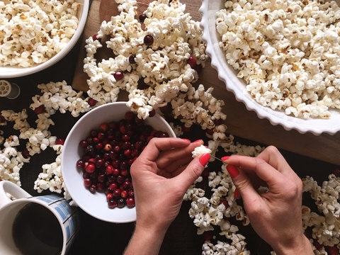 Woman making popcorn and cranberry garland