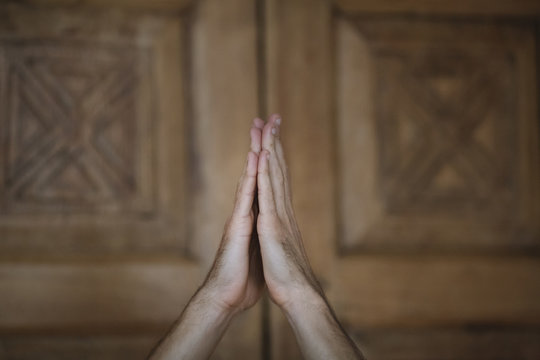 Man meditating with hands up