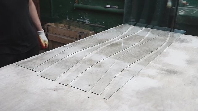 Cutting glass by glass cutter. Man's hands with gloves holding glass cutter.