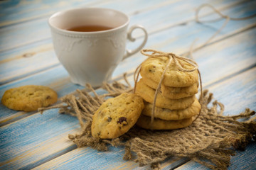 cup of tea with biscuits on a blue wooden background