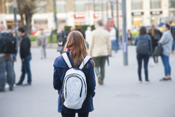 Girl with a backpack on a city street Background is blurred