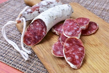 Dried sausage sliced on a cutting board, sausage texture. 