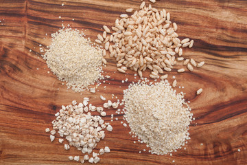 Puffed brown rice, Flaked millet, Quinoa, Puffed Buckwheat and .Puffed Amoranth on a wooden plate