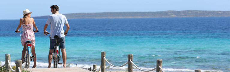 Couple riding bikes on Formentera Island, template