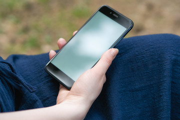 girl in the park enjoys navigation in the smartphone