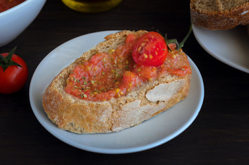 Pa amb tomaquet or tomaca (bread with tomato) also known as pan con tomate and tostada. Classic snack in Catalan cuisine, eaten for breakfast. Crusty bread with fresh cherry ,typical tapa in Catalonia