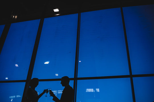 Silhouette of bride and groom toasting with champagne