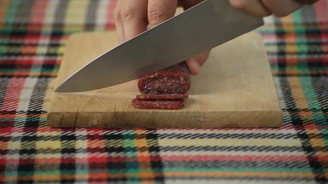 Cutting bulgarian flat sausage called lukanka