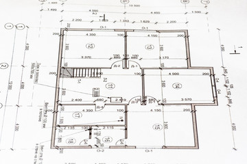 The architectural plan of the house is printed on a white sheet of paper.