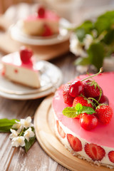 Slice of cheesecake with strawberry filling decorated with cherry jelly and fresh berries. Healthy organic summer dessert pie