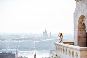 Fototapeta premium View on the wall of Fiserman's bastion with woman standing on the terrace enjoying great view on Budapest city in Hungary