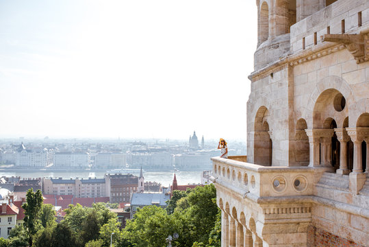 View on the wall of Fiserman's bastion with woman standing on the terrace enjoying the view on Budapest city in Hungary