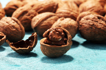 Walnut kernels and whole walnuts on rustic old table