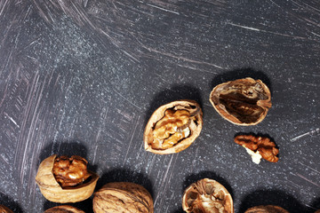 Obraz na płótnie Canvas Walnut kernels and whole walnuts on rustic old table