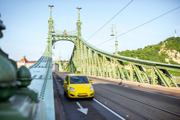 View on the famous Liberty bridge with yellow taxi during the morning light in Budapest, Hungary