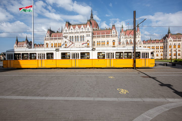Parliamen tbuilding with yellow tram on the central square in Budapest city, Hungary