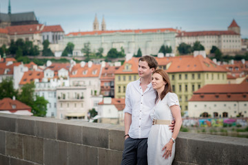 Young couple in love exploring Prague on Charles bridge in Prague