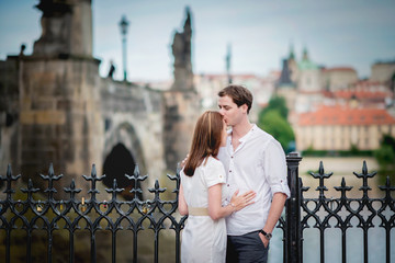 Fototapeta premium Young couple in love near Charles bridge in Prague